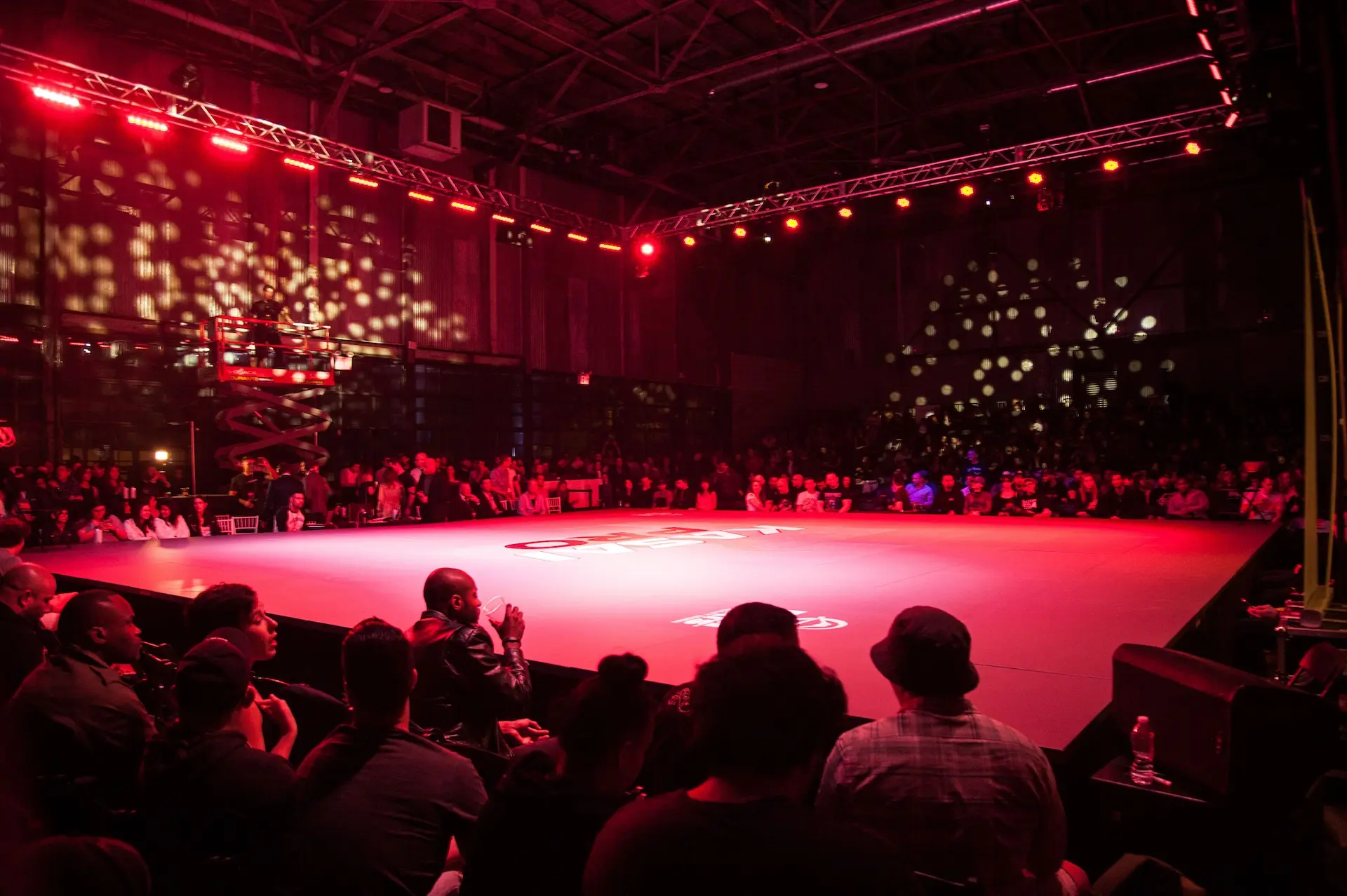 The primary event space featuring a boxing ring and red toned lighting