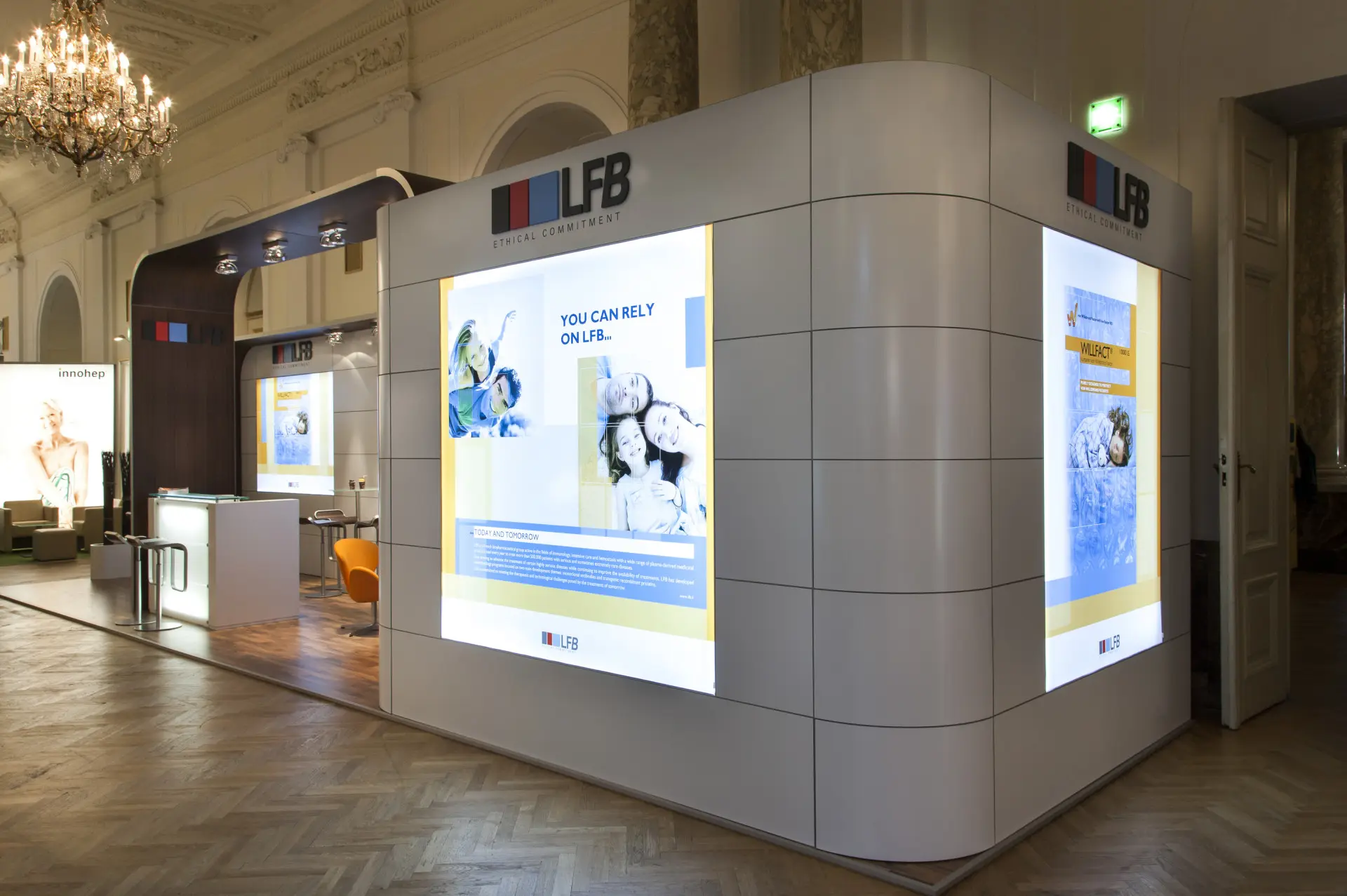 A booth created using a Modular Framing System with curved walls and LED panels