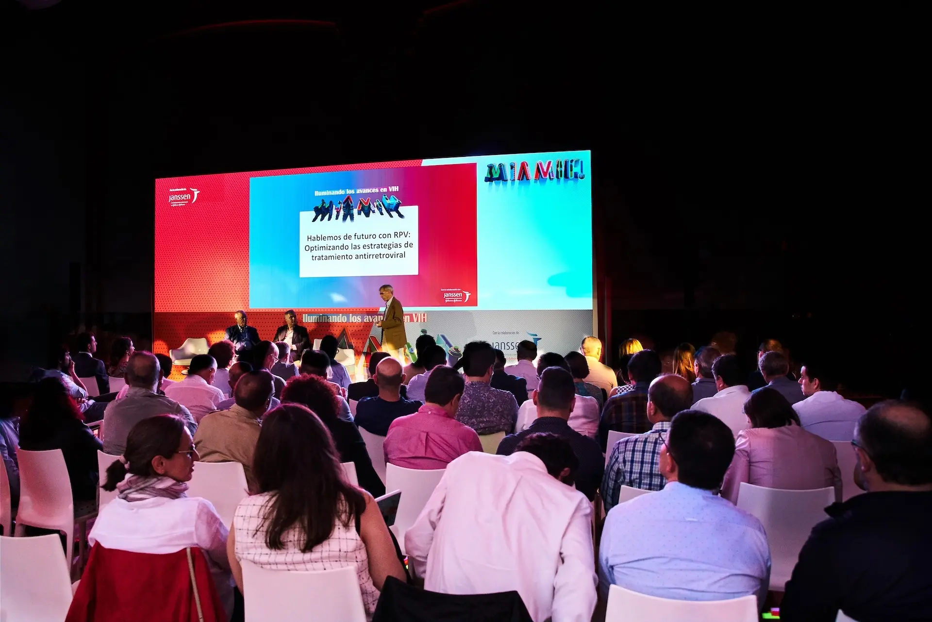 An audience seated facing a rectangular stage during a large event.