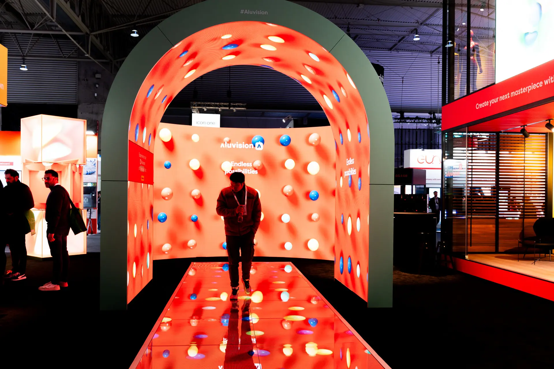 A trade show attendee walking through an LED archway on an LED floor with an LED background