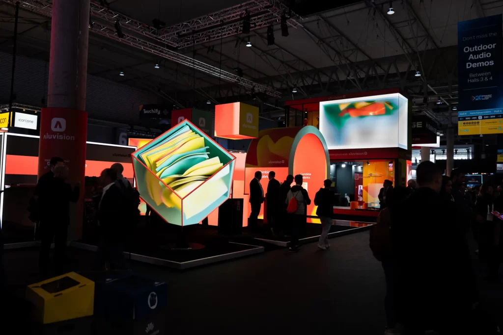 An image from Aluvision's website featuring several 3D LED surfaces at a trade show